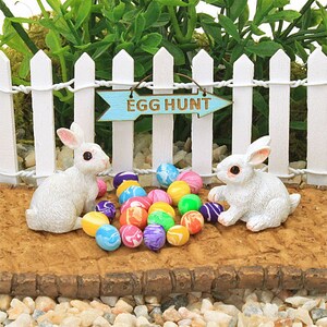 Weisse Osterhasen, bunte Ostereier, weisser Zaun und Gehweg, Ostereiersuche-Schild, Miniatur-Ostern-Kollektion, Feengarten