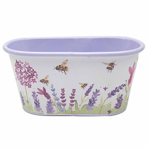 Könnte beinhalten: Ein weißer ovaler Metalltopf mit einem Lavendel- und Bienen-Design. Der Topf hat einen hellvioletten Rand und einen weißen Hintergrund mit einem Aquarell-Design aus Lavendelblüten, grünen Blättern und Bienen.