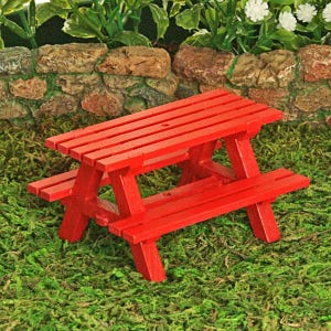 Puede incluir: Una mesa de picnic de madera roja en miniatura con un banco a cada lado. La mesa est&aacute; sentada sobre un lecho de musgo verde.