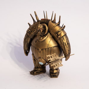 May include: A gold-coloured, articulated robot figurine with a spiky, detailed design. The robot is holding a weapon in its right hand.