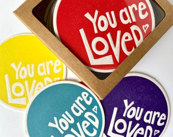 You are Loved Letterpress Drink Coasters in four bright colors - red purple yellow teal