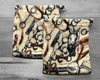 May include: Two brown and white fabric bags with a horse and bridle design. The bags are made of a soft, plush material and have a brown trim.