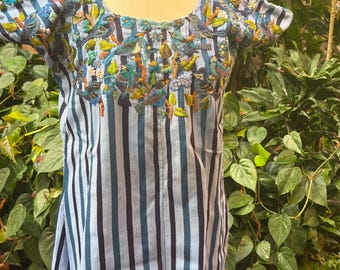 May include: A short-sleeved blouse featuring vertical navy blue and light blue stripes. The neckline and chest area are decorated with intricate, colorful embroidery depicting various small birds perched on branches surrounded by small flowers.