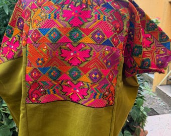 huipil from Chichicastenango , Guatemala. Double headed eagle  and Mayan cosmographic figures in a moss green  hand weaved fabric