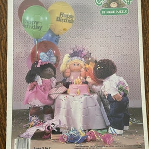 May include: A 25-piece puzzle featuring Cabbage Patch Kids celebrating a birthday with balloons, cake, and confetti. The puzzle is recommended for ages 3 to 7.