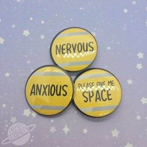 May include: Three yellow and gray round buttons with black text. The buttons read "NERVOUS", "ANXIOUS", and "PLEASE GIVE ME SPACE".