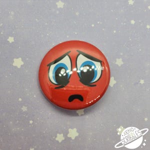 May include: Red button with a sad cartoon face with blue eyes and a frown. The button is on a purple background with white stars.