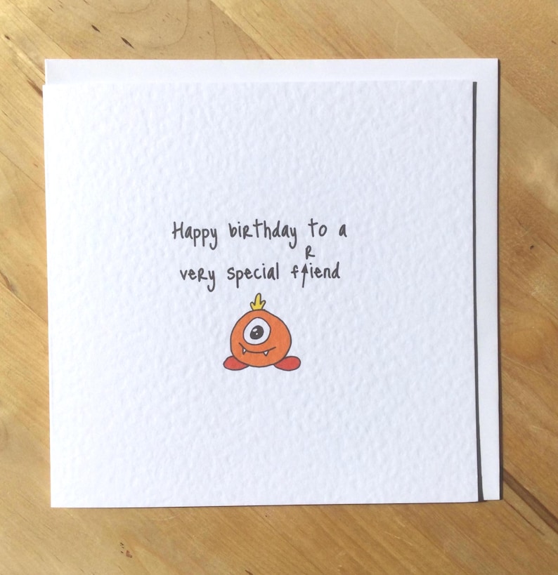 May include: A white ceramic mug with a black handle and the text "But First, Coffee" in a black, handwritten-style font. The mug is on a white surface.