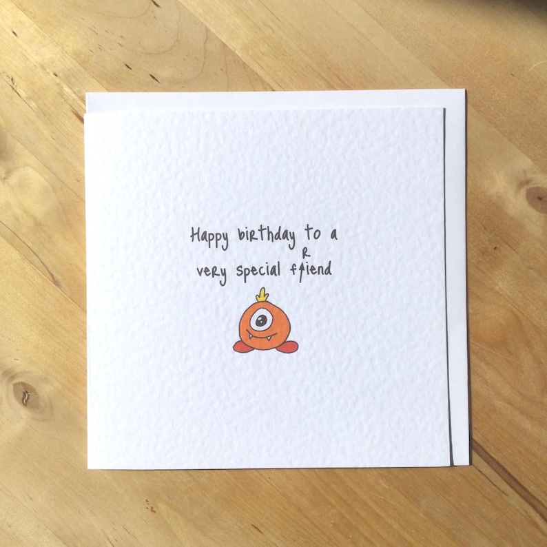 May include: A white birthday card with the message "Happy birthday to a very special friend." The card features a hand-drawn orange monster with one eye and a small flame on its head.