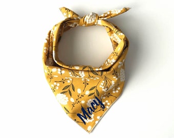 May include: Yellow bandana with a white floral pattern and the name "Macy" embroidered in blue.