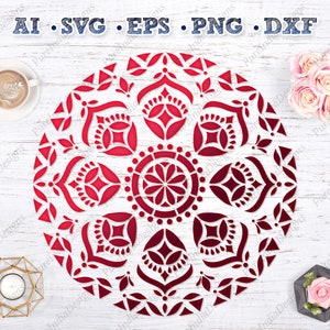 May include: A red and white mandala design with intricate patterns. The mandala is on a white wooden background.
