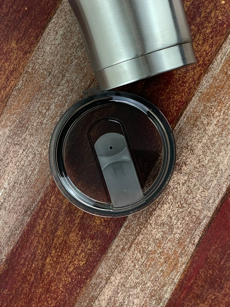 May include: A black lid with a clear plastic insert and a black slider for a stainless steel tumbler.