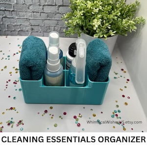 May include: A rectangular light blue plastic organizer with multiple compartments containing two folded teal microfiber cloths, two white spray bottles, and one clear spray bottle. The text WhimsicalWishesUS.etsy.com is visible on the surface.