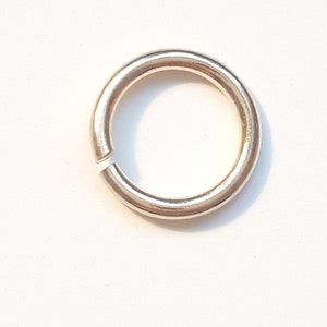 May include: A gold-colored metal jump ring. The ring is round and has a smooth finish.