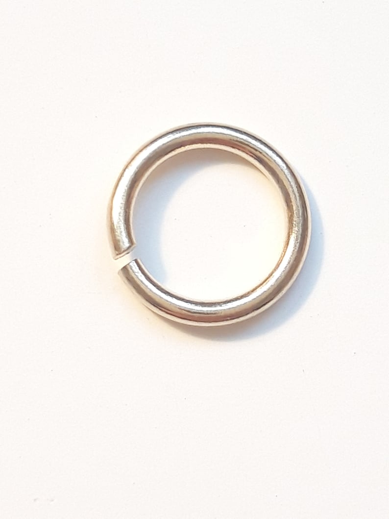 May include: A gold-colored metal jump ring. The ring is round and has a smooth finish.
