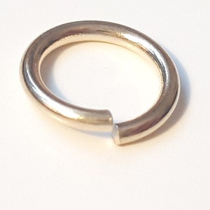 May include: A gold-colored jump ring, a small metal ring used for connecting jewelry pieces.
