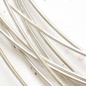 May include: A close-up of a bundle of silver wire, showing the smooth, shiny surface of the wire.