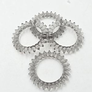 May include: Four clear plastic rings with a scalloped edge. The rings are stacked on top of each other.