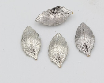 May include: Four silver metal leaf embellishments with a textured design.