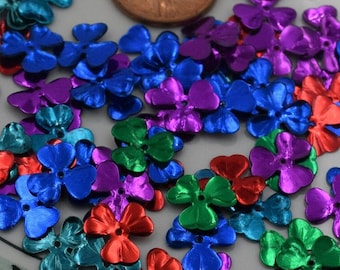Puede incluir: Surtido de lentejuelas metálicas con forma de flor en varios colores, incluyendo azul, verde, morado y rojo.
