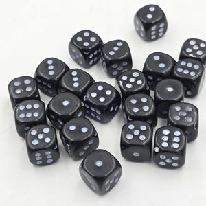 May include: A group of 20 black dice with white dots. The dice are scattered on a white surface.
