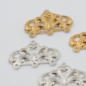 May include: Three ornate metal connector charms with a decorative floral design. The charms are available in gold and silver.