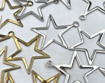 Puede incluir: Una colección de dijes de metal en forma de estrella de color dorado y plateado con un bucle en la parte superior. Los dijes son perfectos para agregar un toque de brillo a las joyas, las manualidades y otros proyectos.