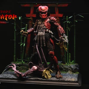 May include: A red and black Predator action figure, posed in front of a Japanese-style torii gate and bamboo stalks. The figure is highly detailed, with intricate armor and weaponry. The text "NIGHTMARE PREDATOR" is visible.