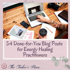 May include: A wooden desk with a laptop, tablet, and smartphone. A person's hand is using the laptop. A coffee cup and notebook are also visible. The text says "54 Done-for-You Blog Posts for Energy Healing Practitioners" and "The Tinker's Moon."