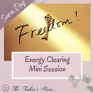 May include: A gold-colored key rests on a golden background with the word "Freedom!" written in cursive. The image also includes text that reads "Energy Clearing Mini Session" and "The Tinker's Moon."