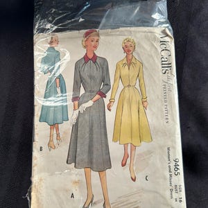 Puede incluir: Patrón de costura McCall's vintage para vestidos de mujer, talla 16. El paquete del patrón presenta ilustraciones de tres diseños de vestidos en gris, amarillo y azul. El texto en el paquete dice "McCall's the first printed pattern".