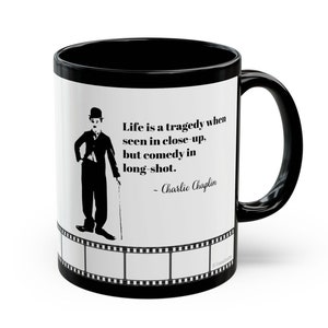 Puede incluir: Taza de café negra con una imagen blanca de Charlie Chaplin y una cita: "La vida es una tragedia cuando se ve de cerca, pero una comedia en plano general. - Charlie Chaplin".