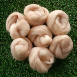 May include: Six balls of light peach coloured wool roving. The wool is soft and fluffy, perfect for felting or spinning.