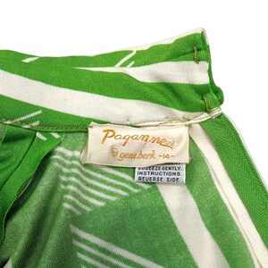 May include: Close-up of a vintage green and white striped garment. The fabric features a bold pattern of diagonal stripes. A tag with the brand name "Paganne" is visible, along with care instructions.