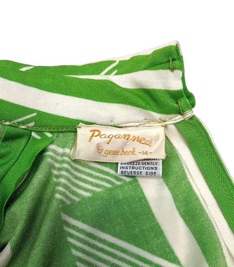 May include: Close-up of a vintage green and white striped garment. The fabric features a bold pattern of diagonal stripes. A tag with the brand name "Paganne" is visible, along with care instructions.