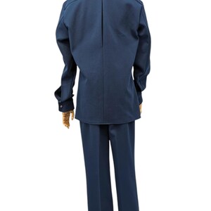 Puede incluir: Un traje azul marino con una chaqueta de manga larga y pantalones a juego.