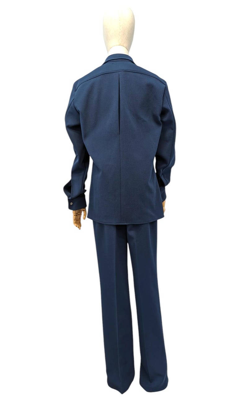 Puede incluir: Un traje azul marino con una chaqueta de manga larga y pantalones a juego.
