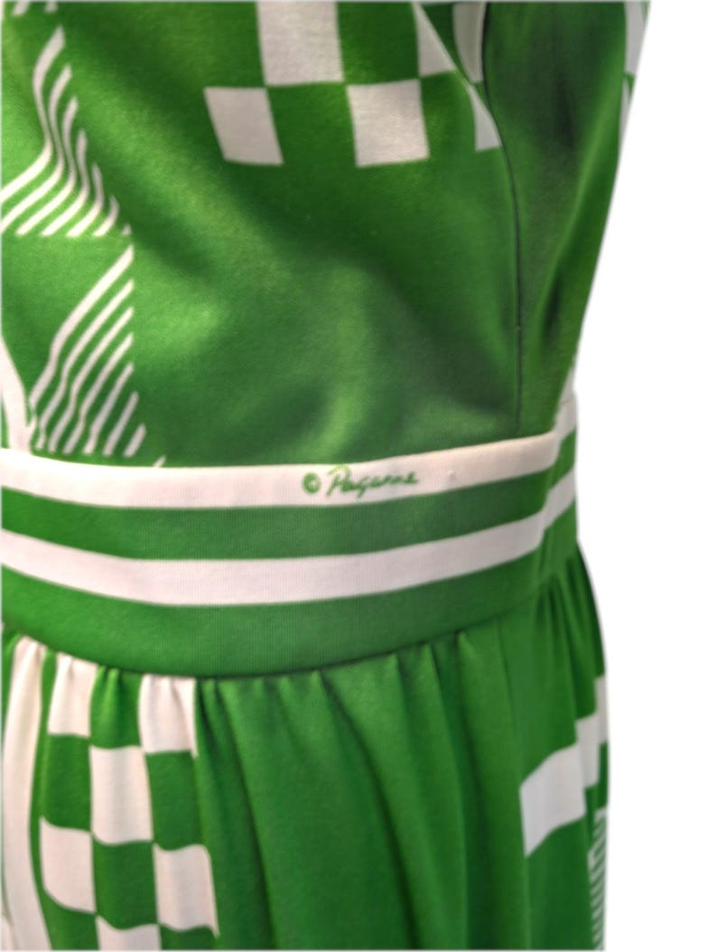 May include: A green and white patterned dress with a checkered and striped design. The dress features a white waistband with the brand name "Haggar" in green script. The fabric is a vibrant green with white accents.