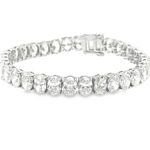 May include: A silver tennis bracelet with oval-shaped cubic zirconia stones.