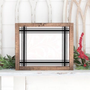 May include: A wooden frame with a black and white plaid design. The frame is empty and ready for a photo or artwork.
