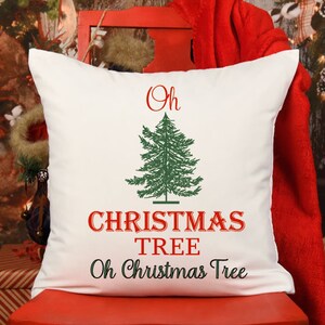 May include: White throw pillow with red and green embroidery. The pillow features a stylized Christmas tree with the text "Oh Christmas Tree" in red.