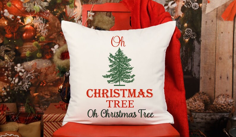 May include: White throw pillow with red and green embroidery. The pillow features a stylized Christmas tree with the text "Oh Christmas Tree" in red.