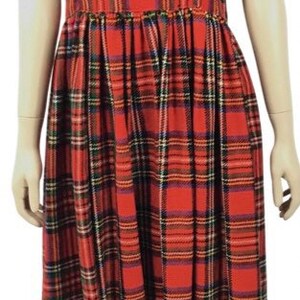 May include: A red, black, and white plaid sleeveless dress with a square neckline. The dress has a fitted bodice and a full skirt.