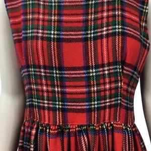 May include: A red plaid sleeveless dress with a square neckline. The dress has a gathered skirt and is made of a soft, comfortable fabric.
