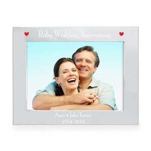 May include: Silver picture frame with a photo of a couple smiling. The frame has the text "Ruby Wedding Anniversary" and "Anne & John Turner 1974-2014" engraved on it.