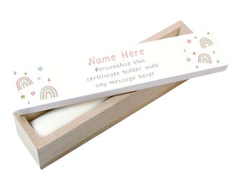 May include: A wooden certificate holder with a white lid. The lid features the text "Name Here" and "Personalise this certificate holder with any message here!" along with rainbow and star illustrations. The holder is open, revealing a white interior.