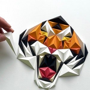 Puede incluir: Una escultura de tigre de papel con un esquema de color blanco, naranja, negro y rojo. La boca del tigre est&aacute; abierta, mostrando sus dientes. La escultura est&aacute; hecha de muchos tri&aacute;ngulos peque&ntilde;os.