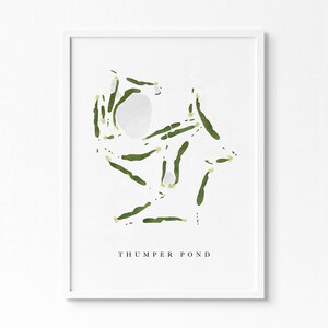 Puede incluir: Una impresión enmarcada en blanco con una ilustración de acuarela verde y amarilla de un diseño de campo de golf. El texto "THUMPER POND" está impreso debajo de la ilustración.