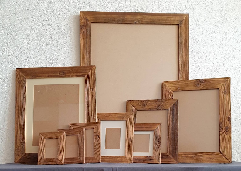 May include: A set of eight rustic wooden picture frames in various sizes. The frames are made of natural wood with a brown finish and have a simple, rectangular design.