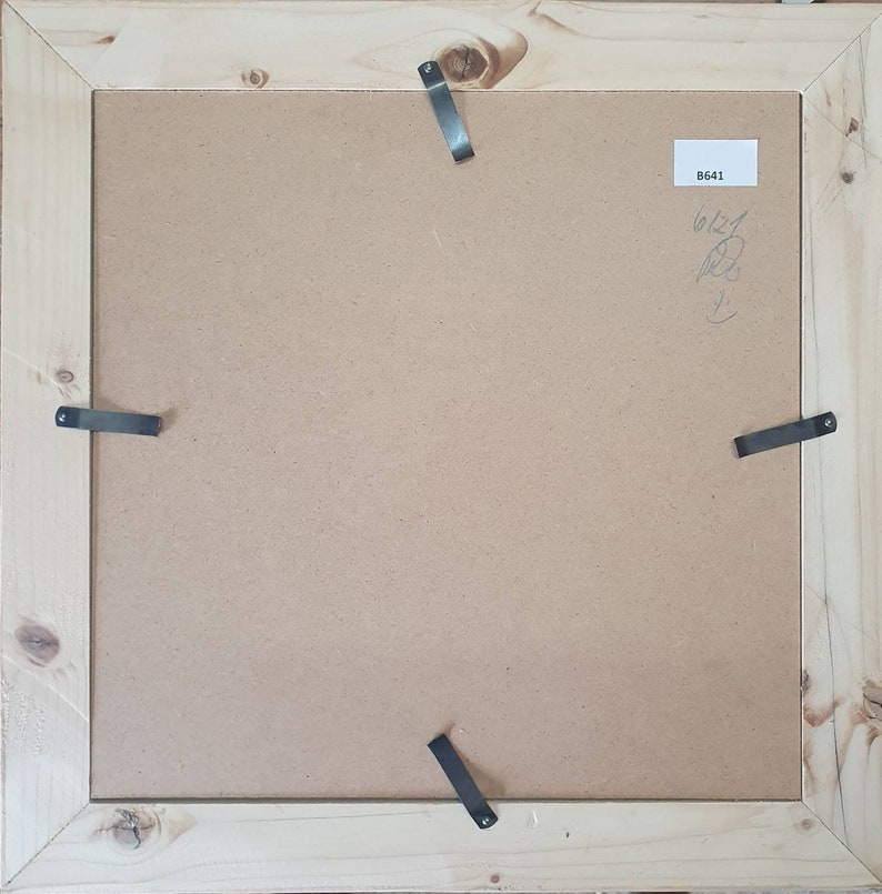 May include: The back of a wooden picture frame with four metal hanging clips. The frame has a brown paper backing with the number "B641" written on it.